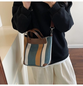 Close-up of striped canvas tote showing leather handles and woven texture details