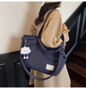 Détail du grand sac de voyage bleu marine en nylon avec un pendentif nuage blanc