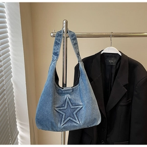 Detail of vintage washed blue denim tote bag with embossed star pattern on fabric