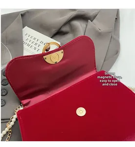 Detail view of the red velvet handbag featuring a strong magnetic gold clasp closure