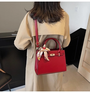 Detail of red leather wedding handbag with silk scarf handle and metal turn-lock closure
