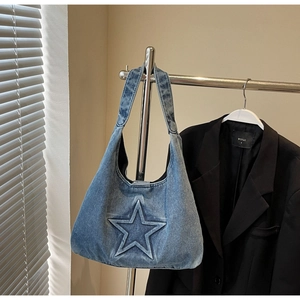 Close-up of light blue denim hobo bag featuring a distinctive 3D star-shaped embossed design