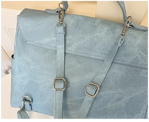 Detailed back view of light blue backpack showing adjustable straps and silver metal hardware