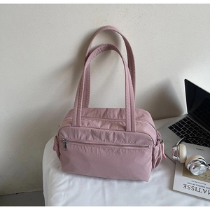 Close-up of pink nylon tote bag with functional drawstring side pockets and front zipper