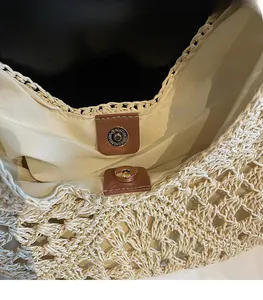 Detail view of woven tote bag featuring a magnetic snap closure and gold-tone hardware