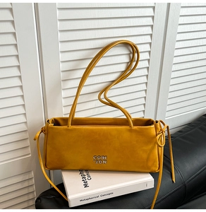 Détail du sac à bandoulière rectangulaire gingembre avec logo en métal et cordon