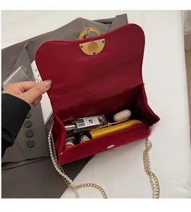 Detail showing red velvet chain bag interior with space for perfume and phone