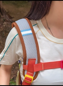 Détail de la bandoulière en maille bleue respirante avec sangle orange et boucle jaune