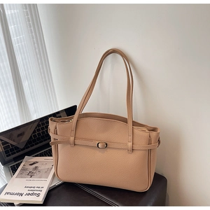 Detailed close-up of apricot lychee pattern leather tote bag with long straps and hardware