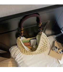 Detail of hand-woven tote bag showing large interior space and purple rope handle with beads