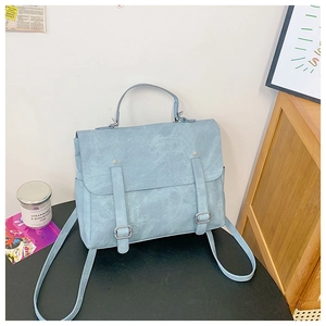 Detail of light blue vintage backpack with dual buckles and textured matte finish