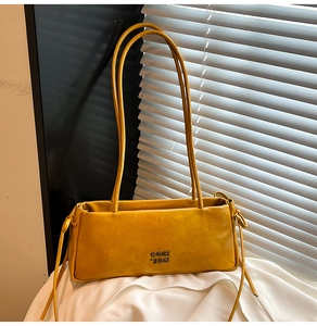 Détail du sac en cuir jaune avec logo et bandoulière nouée élégante en gros plan