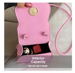 Detail showing internal capacity of the pink mini leather saddle bag with a lipstick