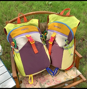 Détail du sac à dos en nylon multicolore avec design de blocs de couleurs sur l'herbe
