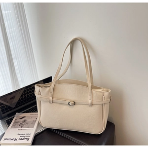Close-up of cream lychee texture leather tote bag with silver buckle and office props