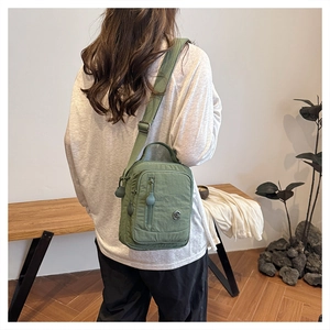 Detail view of army green nylon crossbody bag with multi-pockets and adjustable strap