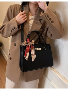 Classic black leather handbag with silk scarf and gold lock shown on model