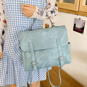 Detail of light blue vintage satchel with silver buckles and matte texture finish