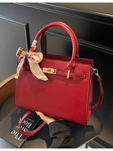 Elegant red wedding handbag with gold lock and decorative silk scarf on handle