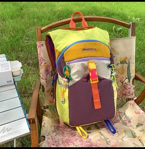 Sac à dos d'extérieur multicolore sur une chaise de camping avec boucles et poches latérales