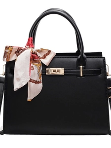 Structured black leather handbag with a gold twist lock and elegant printed silk scarf wrap