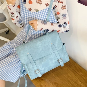 Detail of vintage sky blue faux leather bag featuring dual buckle straps and side pocket