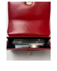 Interior view of red leather crossbody bag showing capacity for phones and cosmetics