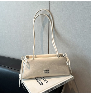 Vue détaillée du sac baguette blanc crème avec logo en métal argenté et nœud sur le côté