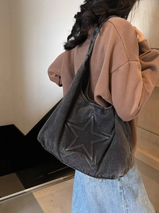 Black washed denim tote bag with large 3D star embossment shown on shoulder