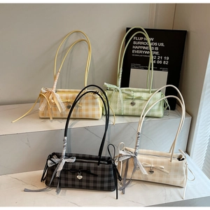 Detailed display of plaid shoulder bags in pastel yellow, green, grey, and cream with bows