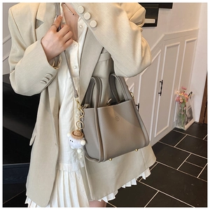 Detail of grey pebble leather mini tote with shoulder strap and cute lamb charm pendant