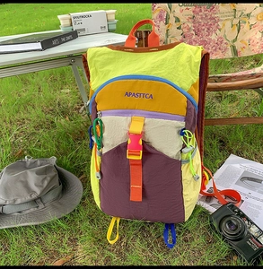 Gros plan sur un sac à dos extérieur multicolore avec design patchwork sur l'herbe