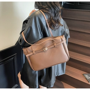 Detailed view of the brown lychee pattern leather tote bag with elegant metal buckle