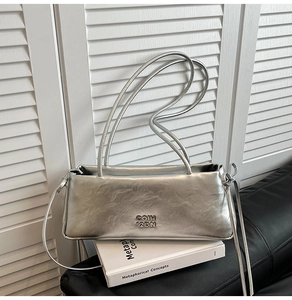 Gros plan sur le sac baguette argenté à texture froissée et logo métallique élégant