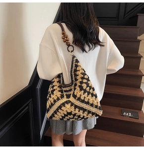 Detail of woven tote bag with contrast geometric patterns and wooden bead strap accents