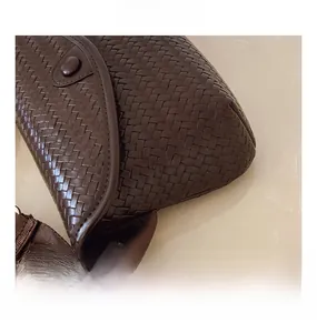 Détail de la texture en cuir tressé marron foncé d'un sac à bandoulière élégant