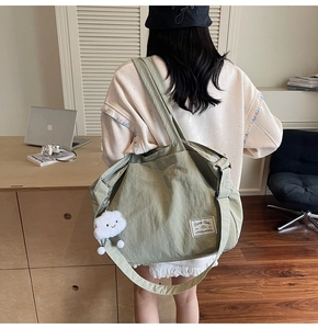 Détail du sac de voyage en nylon froissé vert gris avec pendentif nuage en peluche