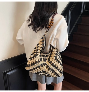 Detail of woven tote bag featuring geometric patterns and decorative wooden bead strap