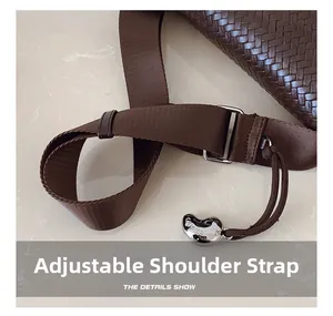 Détail de texture en cuir tressé marron avec bandoulière réglable et breloque en métal