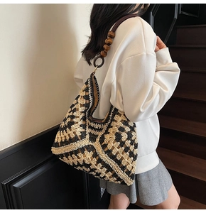 Detail of woven tote bag with contrast geometric patterns and wooden bead straps