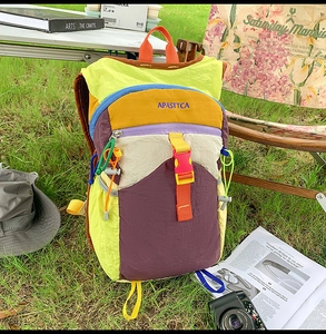 Vue détaillée du sac à dos extérieur coloré en nylon sur l'herbe verte