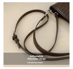 Détail du sac seau marron foncé en cuir tressé avec bandoulière réglable et boucle argentée