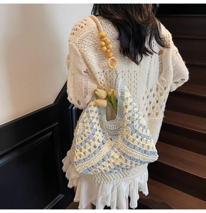 Detailed close-up of a woven tote bag featuring geometric patterns and wooden beads