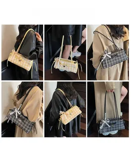 Detail showing checkered shoulder bag with lace bow and heart pendant on model
