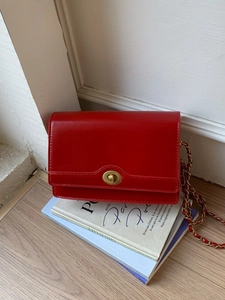 Elegant red leather flap bag with vintage gold turn-lock and chic chain shoulder strap