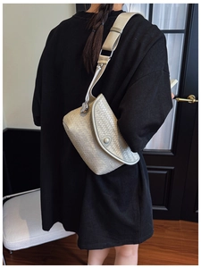 Détail de la texture en cuir tressé et du pendentif en forme de cœur sur ce sac à bandoulière