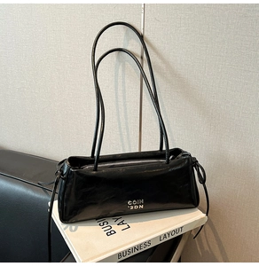 Gros plan d'un sac porté épaule noir mat avec doubles fines bandoulières et zip métallique