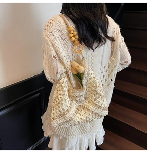 Detail of hand-woven crochet tote bag with wooden bead strap and net hollow pattern