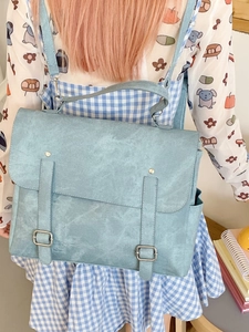 Light blue vintage college style backpack with double decorative straps and metal buckles