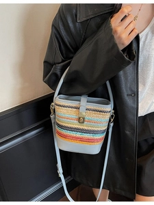 Handmade striped woven straw bucket bag with blue leather strap and metal clasp
